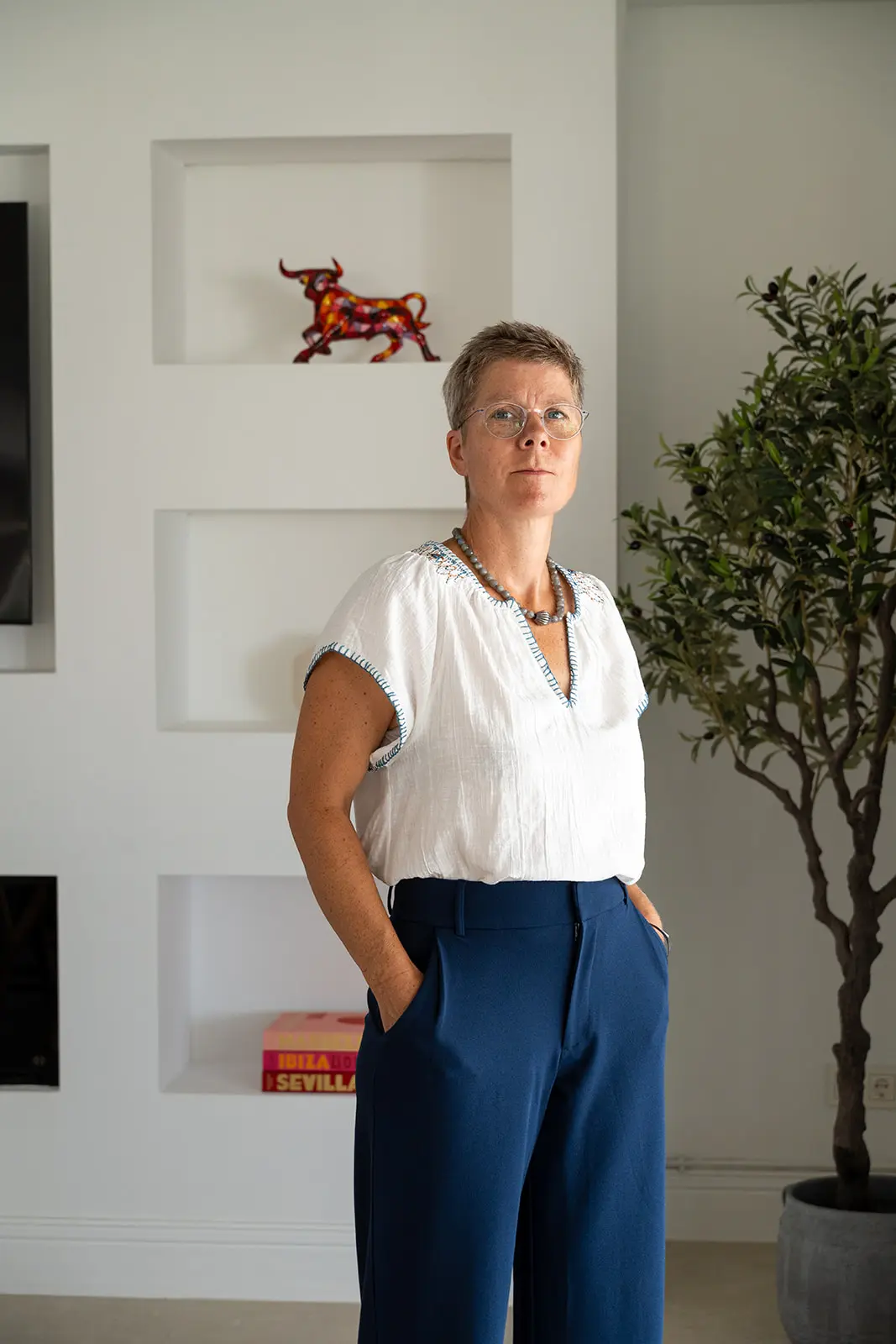 Mette standing in a bright, white-walled living room